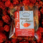 Clear plastic bag containing a label that reads 'Dried Carolina Reaper' among a bed of red dried peppers.